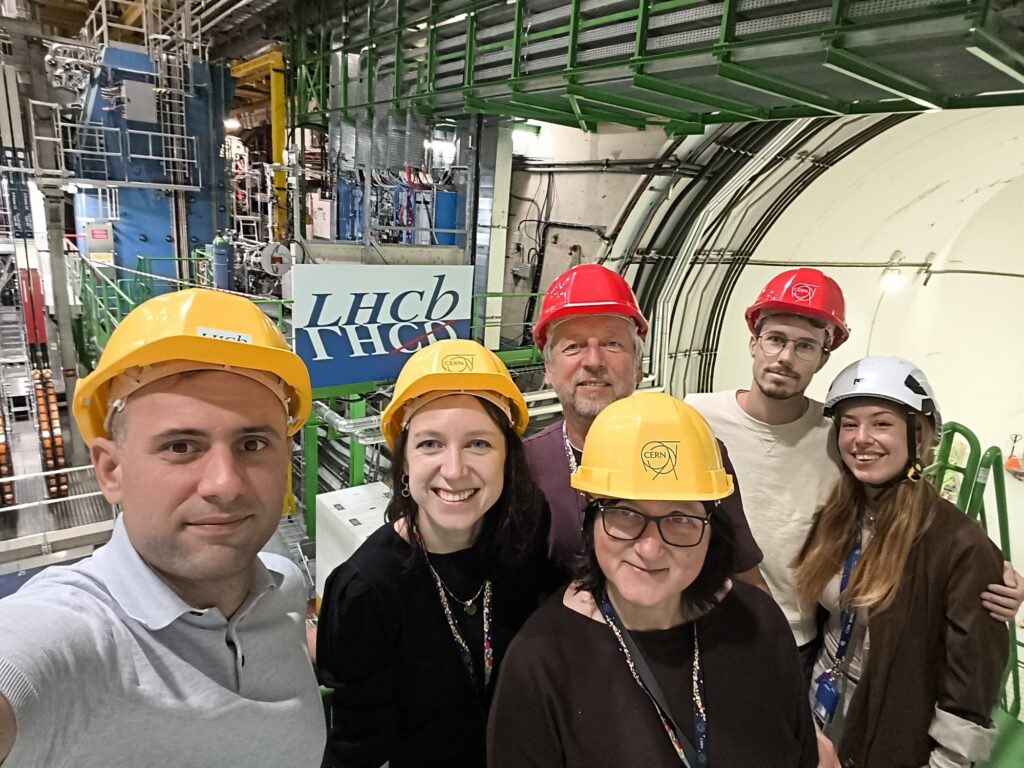 Grupowe zdjęcie zespołu w kaskach przy detektorze LHCb w CERN